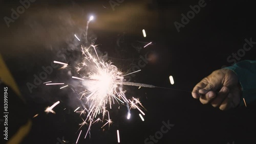 Pencil crackers or indian Phuljhadi fireworks holding in hand at Diwali festival celebration