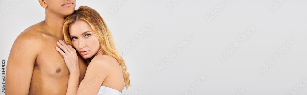Chic man and woman pose together on white backdrop. Chic man and woman pose together on white backdrop.