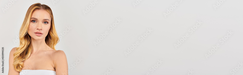 Woman in white dress poses elegantly against a white backdrop. Woman in white dress poses elegantly against a white backdrop.