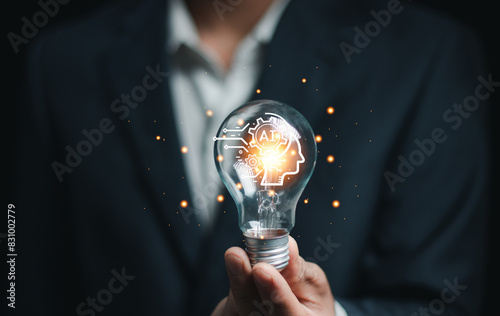 hand holding a light bulb. artificial intelligence or AI of future innovation technology concept, applying technology to business in the digital age. empowering global business AI..