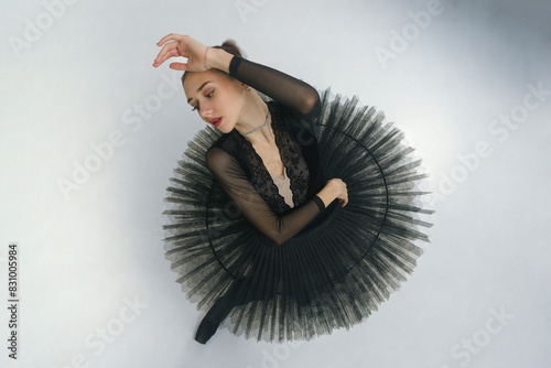 portrait of a young ballerina in a black tutu dancing with her hands moving top view, immersion in dance