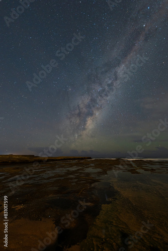 Milky way view from rocky coastline.