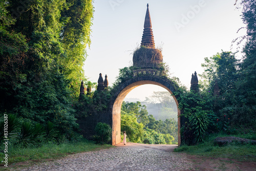 Asian female tourist standing at The large ancient pagoda arch is beautiful, Khao Na Nai Luang Dharma Park, Surat Thani, Thailand.