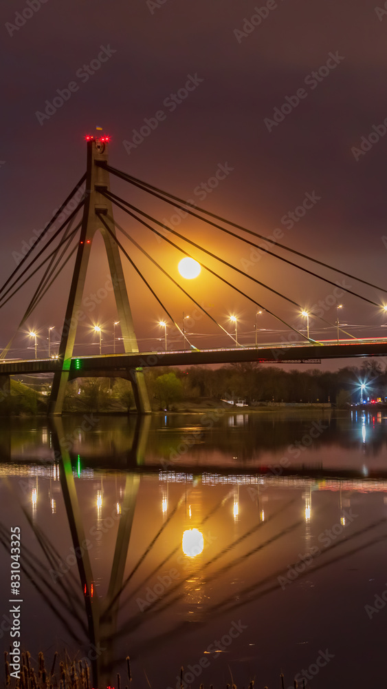 Obraz premium Full Moon rising on background bridge in Kyiv, Ukraine