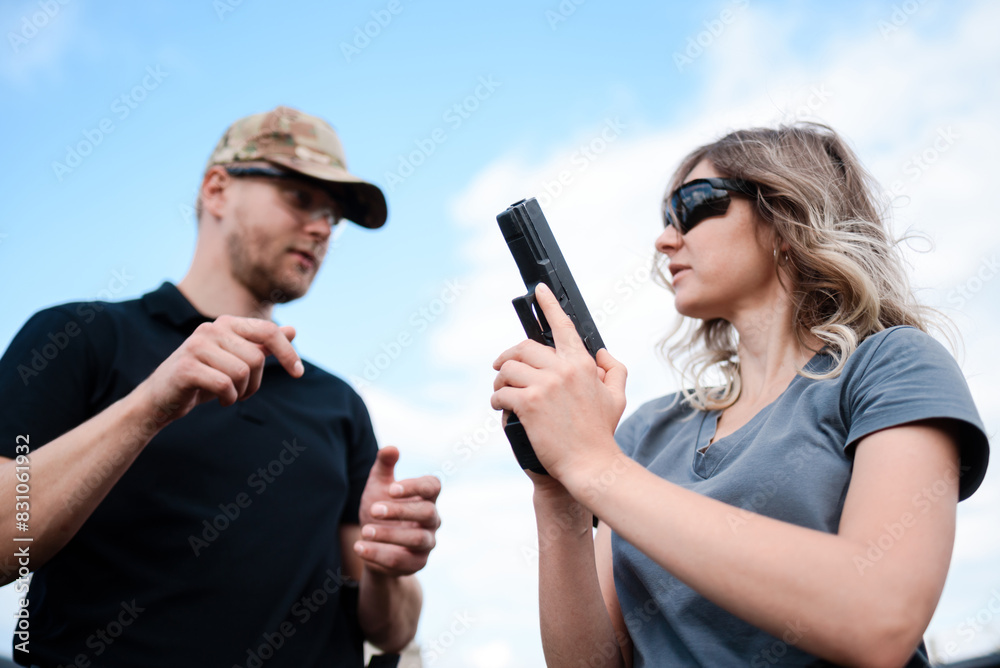 A girl learns to shoot a pistol at a shooting range with an instructor A girl learns to shoot a pistol at a shooting range with an instructor