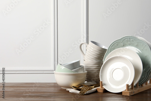 Beautiful ceramic dishware  cups and cutlery on wooden table  space for text