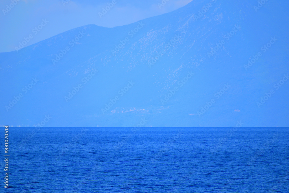 Obraz premium seascape with a cloudy mountain - mount Athos, Greece, aegean sea
