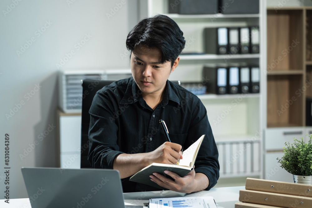 Young employee using computer working online, doing searching, taking notes, watching business training webinar in office, having virtual chat meeting looking at laptop at work. Young employee using computer working online, doing searching, taking notes, watching business training webinar in office, having virtual chat meeting looking at laptop at work.
