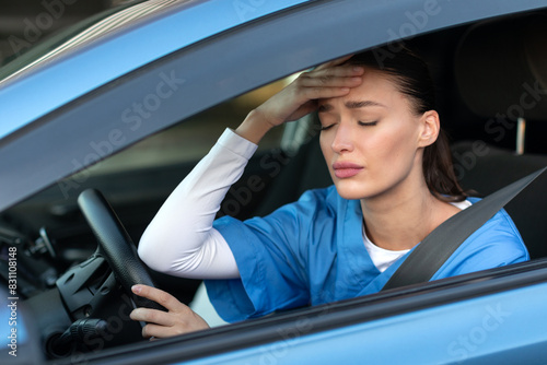 Work-life balance of healthcare worker. Tired nurse crying in car, going home after hard work day, doctor feeling exhausted. photo