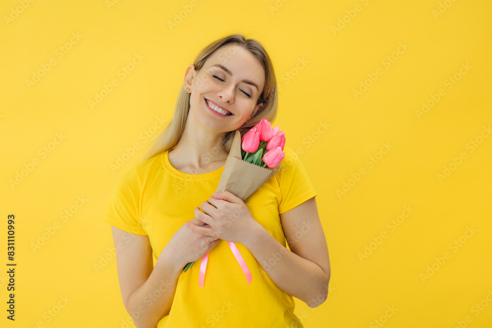 beautiful attractive stylish woman in yellow t-shirt holding flowers tulips isolated in love summer fashion trend style, natural look