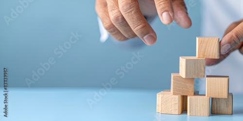 Closer up hands of businessmen,stacking wooden blocks into steps