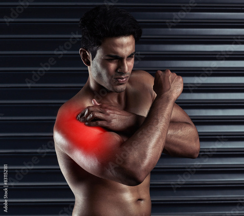 Shoulder pain, sports or man with injury or body ache in fitness training, exercise or workout. Dark background, red glow colour or bodybuilding athlete with bruised arm in accident or gym studio