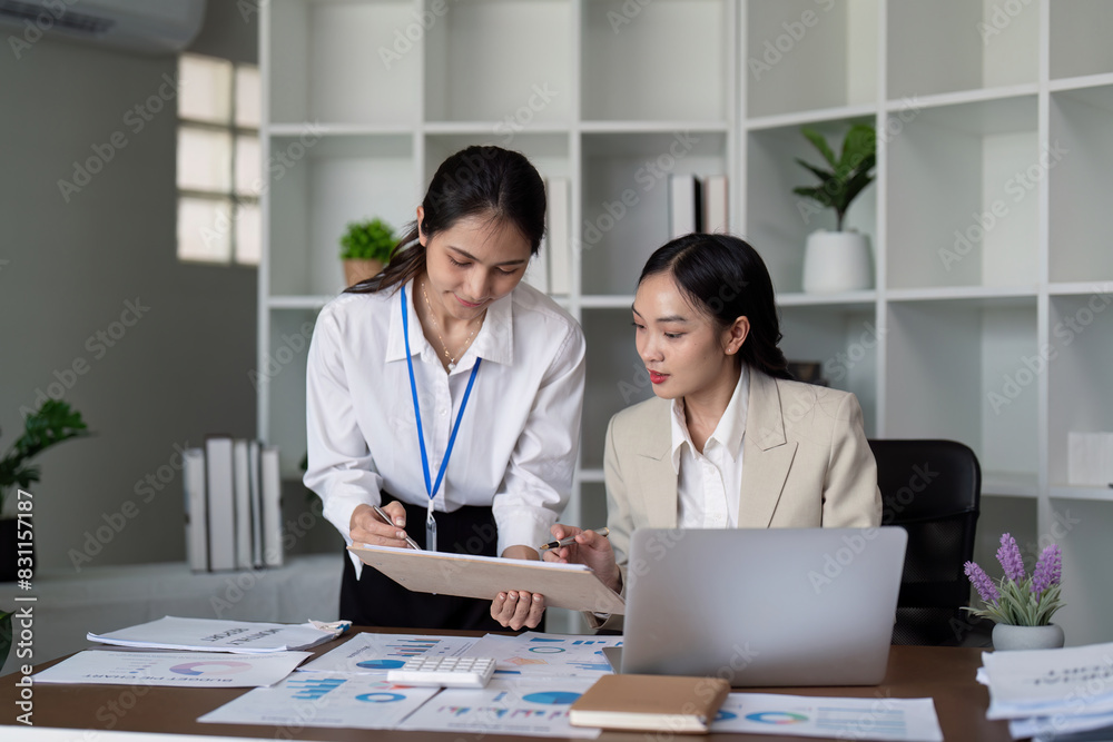 Two businesswomen collaboration on financial documents at the office. Concept of teamwork, data analysis, and professional cooperation Two businesswomen collaboration on financial documents at the office. Concept of teamwork, data analysis, and professional cooperation