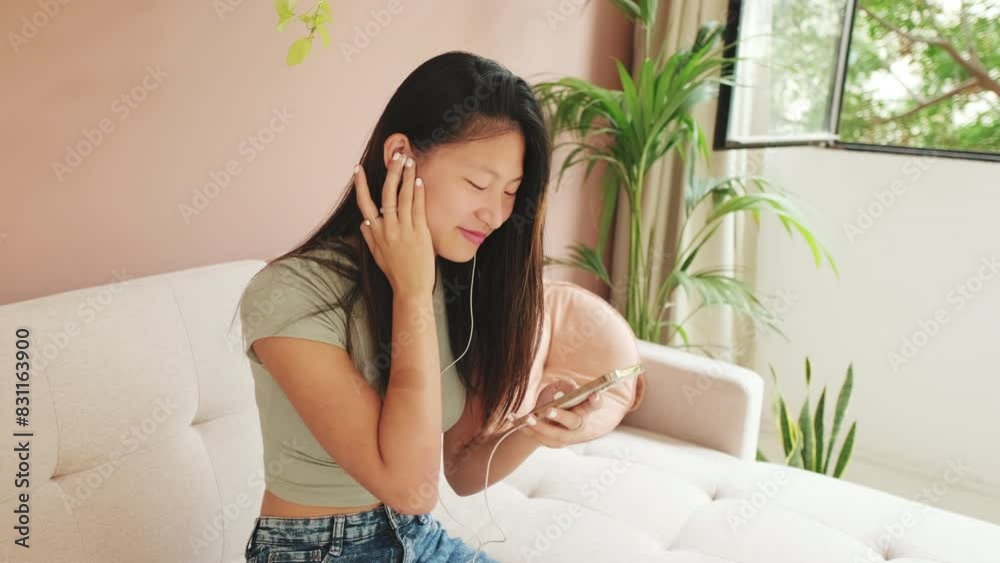 Young woman in headphones with a phone in her hands listens to music Young woman in headphones with a phone in her hands listens to music