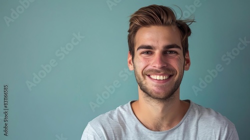confident young man friendly smile and casual attire exude positive attitude studio portrait