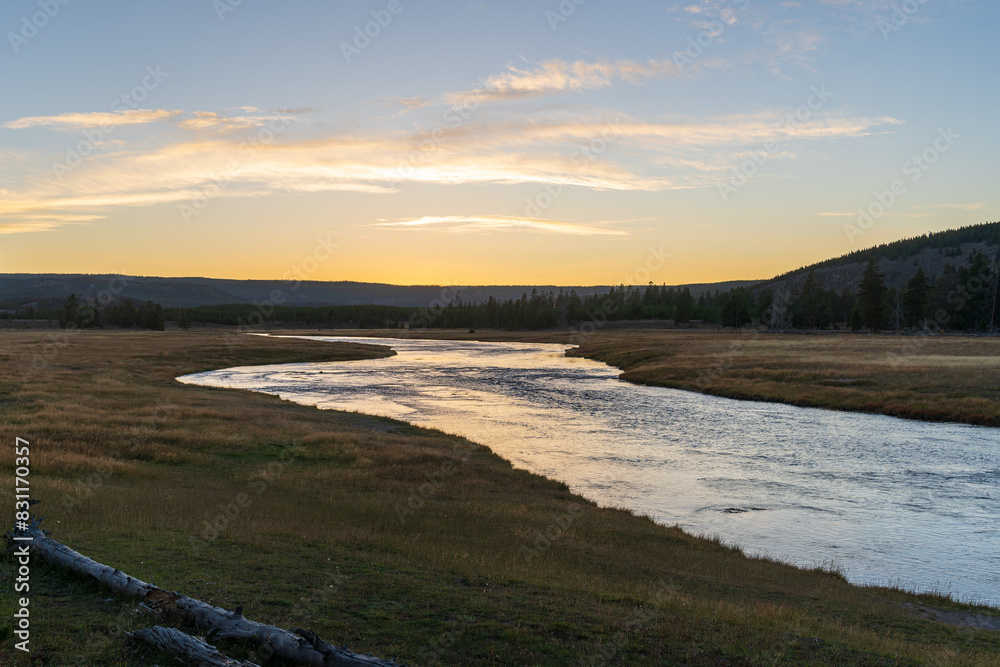 The Firehole River flows through Yellowstone National Park in Wyoming at sunset and golden hour on a fall evening. The Firehole River flows through Yellowstone National Park in Wyoming at sunset and golden hour on a fall evening.