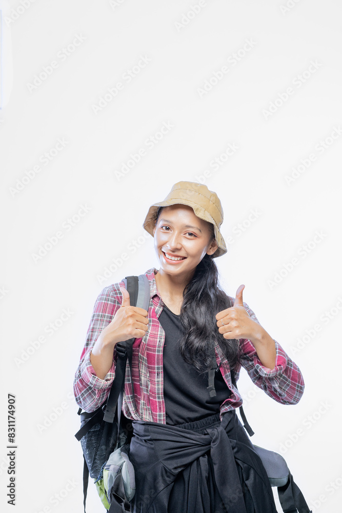 Portrait of an Asian backpacker girl showing thumbs up and smiling cheerfully Portrait of an Asian backpacker girl showing thumbs up and smiling cheerfully