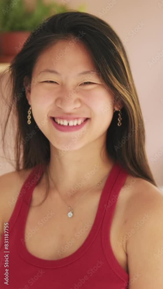 Laughing young woman looking at camera while standing in living room Laughing young woman looking at camera while standing in living room