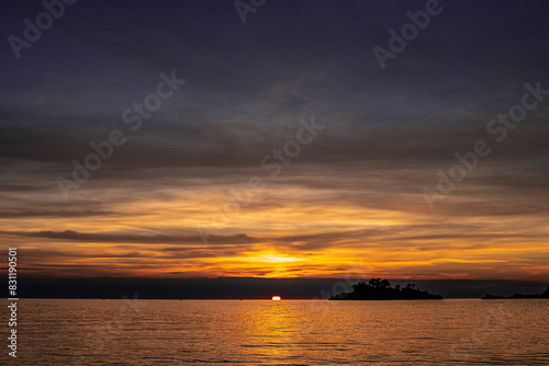 sunset over the sea with bright sun and dark clouds