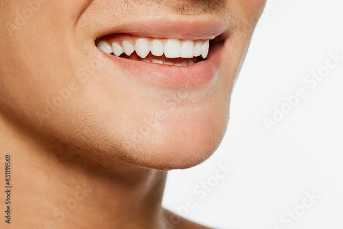 Close up photo of male face with perfect  white smile against white background. Dental health and hygiene. Concept of male health  beauty and self care  youth  body and skin care.