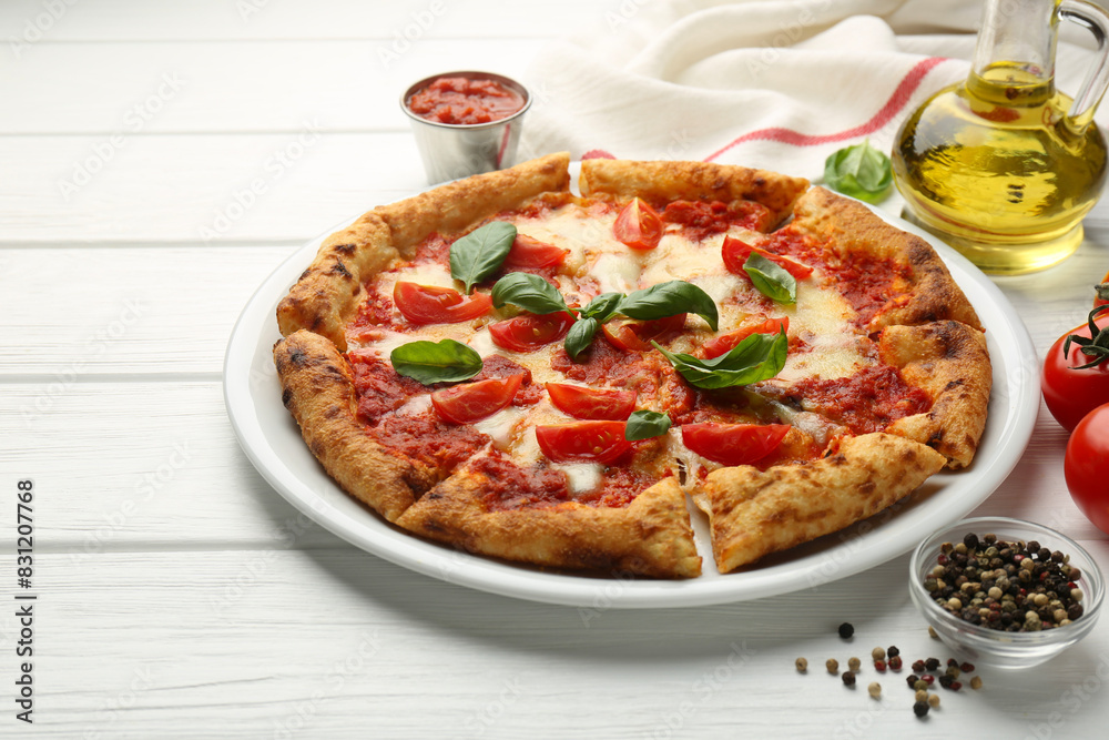 Delicious Margherita pizza and ingredients on white wooden table Delicious Margherita pizza and ingredients on white wooden table