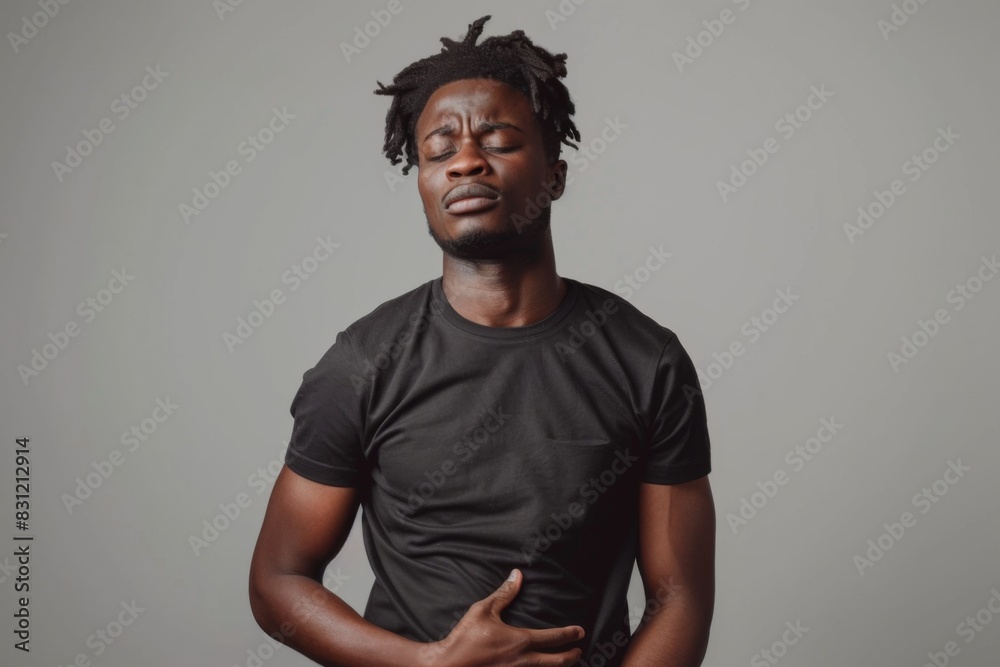 A man with long dreadlocks stands confidently in front of a gray backdrop A man with long dreadlocks stands confidently in front of a gray backdrop