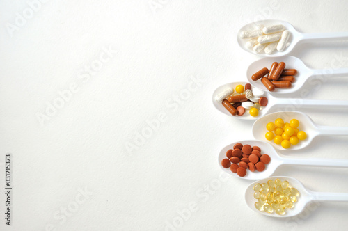 Tablets  capsules  dietary supplements  vitamins on spoons. Medical background