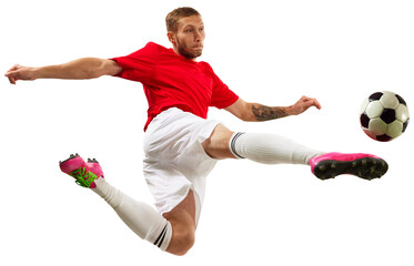 Young soccer soccer player looks confident practicing kicking ball in motion against transparent background. Football school. Concept of game, sport, recreation, active lifestyle.