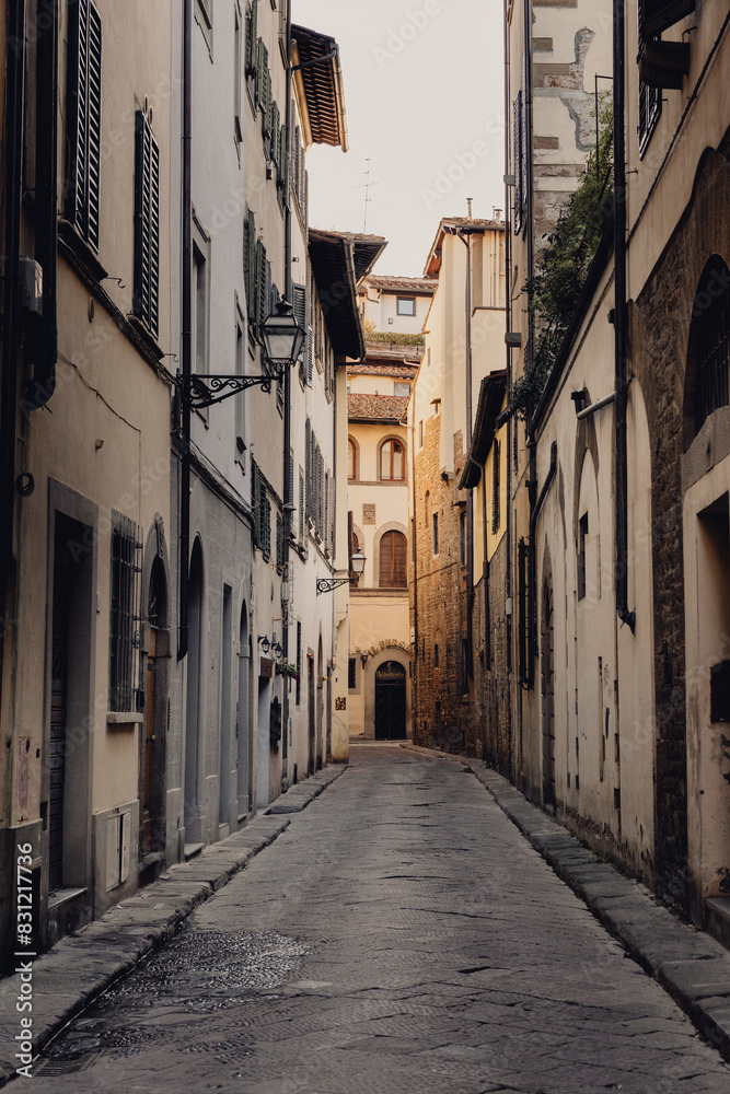 Fototapeta premium Vertical photo of an empty street of the old city center of Florence in the early morning without people