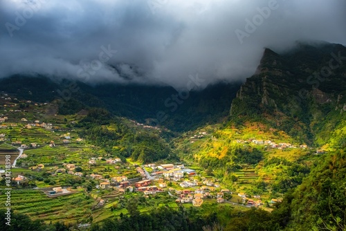 Traditional terrace village Sao Vicente  Madeira Island  Portugal. Small houses and gardens among a green mountain landscape in stormy weather.