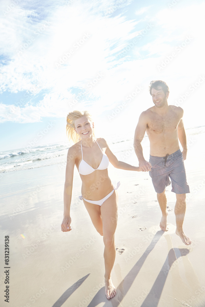 Holding hands, running and portrait of couple on beach for travel, vacation or holiday with romance together. Happy, summer and young people walking by ocean for bonding on weekend trip in Australia.