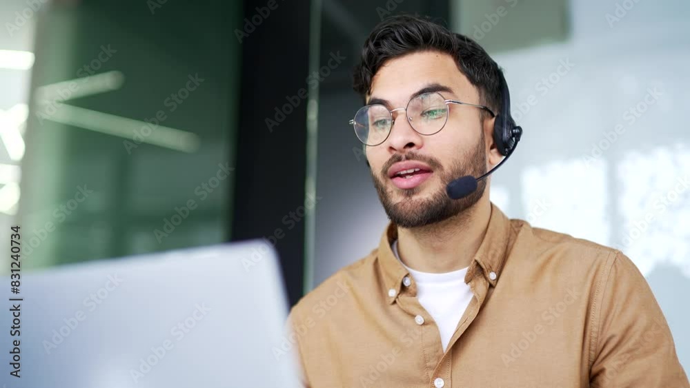 Corporate operator who works in customer support speaks on a video call using a laptop computer. Call center agent in wireless headset helping with complaints in office. Online consultation. Close up 