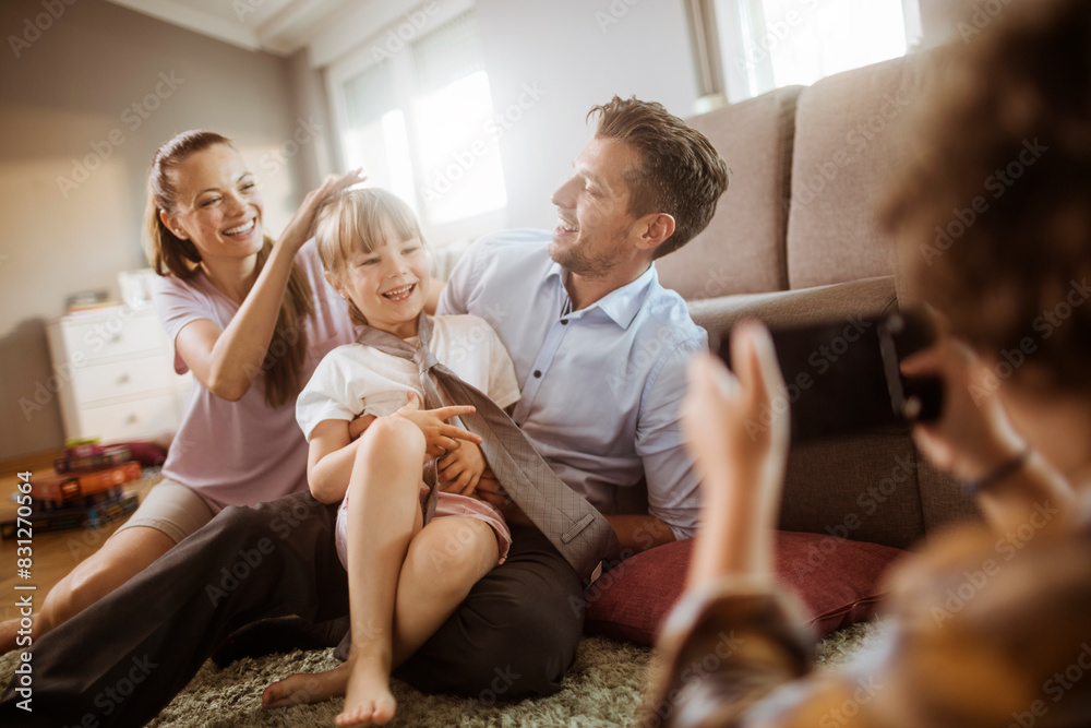 Family playing together on living room floor while being photographed Family playing together on living room floor while being photographed