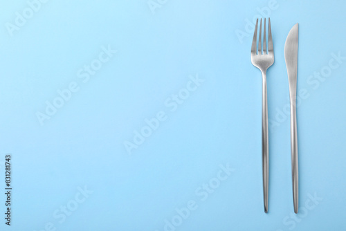 Stylish cutlery on light blue table, top view. Space for text