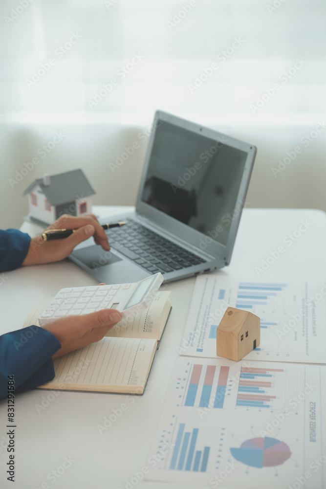 Fototapeta premium Businessmen holding pens, signing home titles with insurance, care about real estate services and the idea of real estate agents offering interest in installments to their customers.