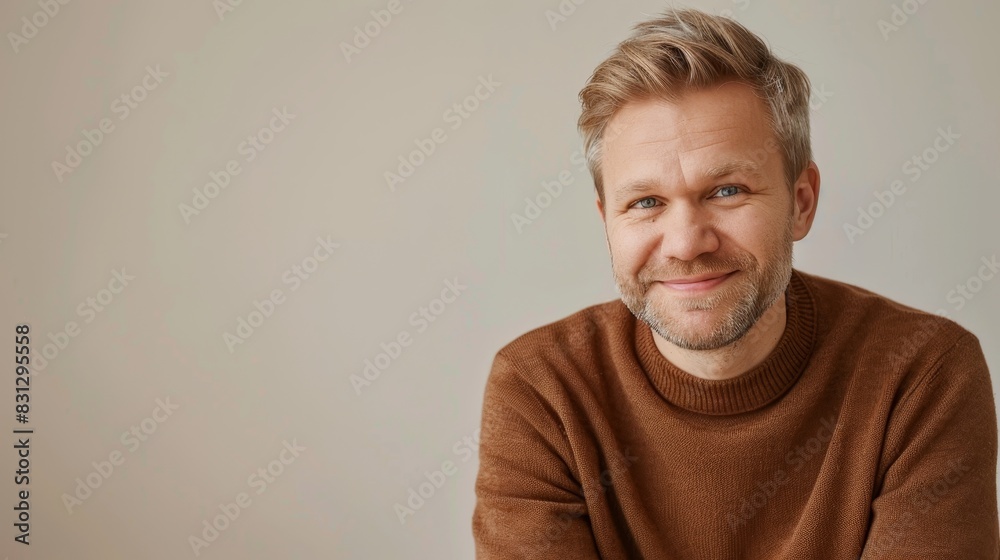 portrait of scandinavian softly smiling man is 35 years old with blond hair on solid light beige color background with copy space portrait of scandinavian softly smiling man is 35 years old with blond hair on solid light beige color background with copy space