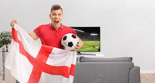 Obraz na plátne Excited soccer fan holding a football and an English flag