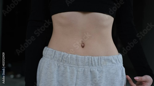 Young woman doing breathing exercises vacuum closeup belly