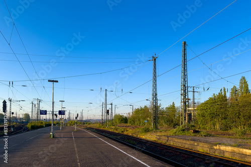 Empty railway platform and train tracks .