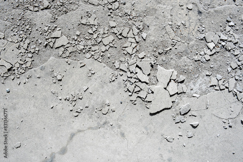 Damaged concrete floor with pieces of cement plaster and cracks photo