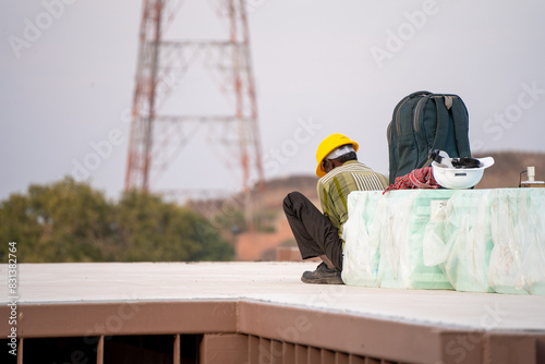 Dejected sad labourer sitting squatting showing the declining safety and wages in the Indian real estate market photo