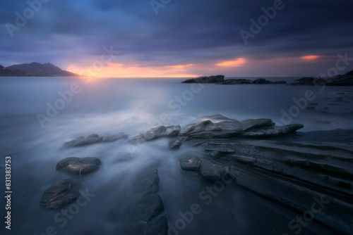 sunset in cold tones with water between the rocks in the foreground on Lastron beach in Muskiz  Bizkaia