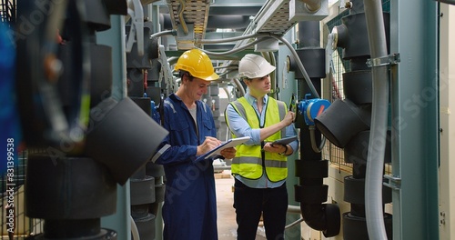 Civil engineer manager and foreman worker checking industry cooling air conditioner water cooling tower air chiller of large industrial building to control air system at construction site