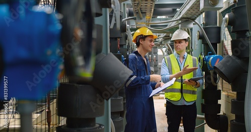 Civil engineer manager and foreman worker checking industry cooling air conditioner water cooling tower air chiller of large industrial building to control air system at construction site