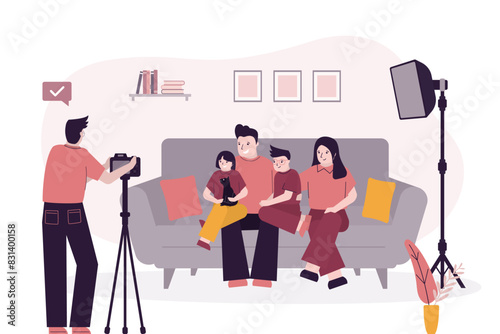 Happy family portrait, people sitting on the sofa and photographer taking photos. Father, mother, son and daughter together before camera.