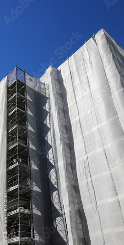 scaffolding of a building with many apartments during the installation of insulation panels for energy consumption reduction photo