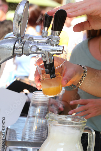 bartender pouring a glass of fresh lager beer during outdoor party