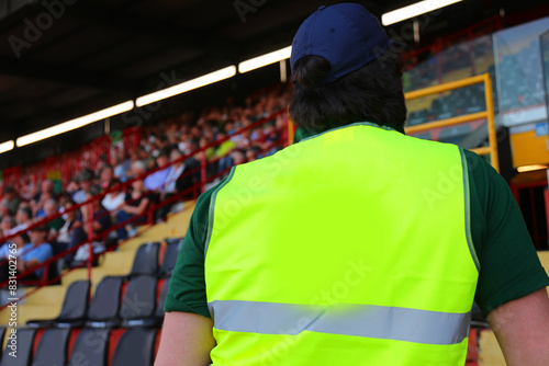 Fotografi Man with fluorescent jacket while checking the audience in the stands of the pac