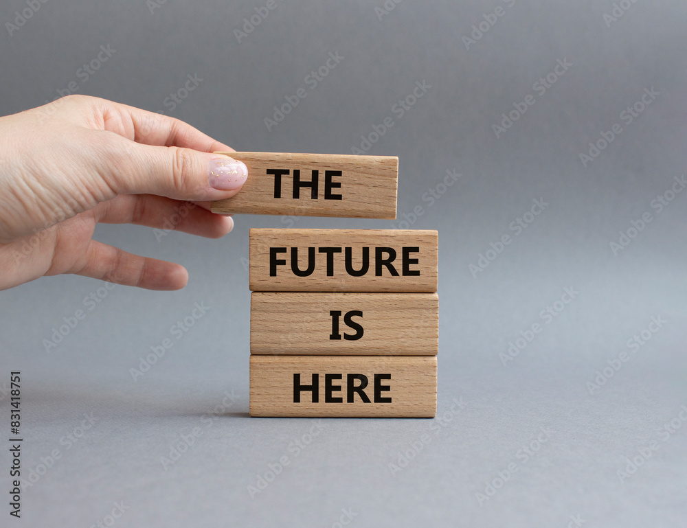 The future is here symbol. Concept words The future is here on wooden blocks. Beautiful grey background. Businessman hand. Business and The future is here concept. Copy space. The future is here symbol. Concept words The future is here on wooden blocks. Beautiful grey background. Businessman hand. Business and The future is here concept. Copy space.