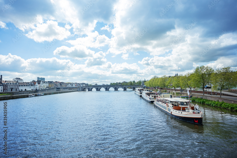 Boats docked by a Maastricht city river Meuse, Holland at spring Boats docked by a Maastricht city river Meuse, Holland at spring